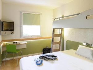 a bedroom with a bed and a bunk bed with a television at ibis budget Dresden City in Dresden +23 photos