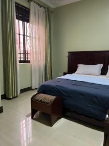 a bedroom with a large bed and a window at Paradise in najjera in Kampala