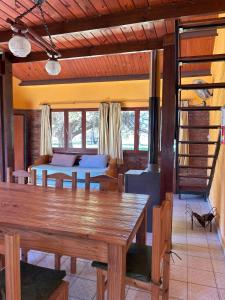 a dining room with a wooden table and a bed at Ecoparque Kooch in Sierra de la Ventana