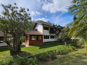 a house with a green yard with a tree at Casa Incrível em Nova Friburgo - Espaço Humedica in Nova Friburgo