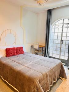 a bedroom with a large bed with red pillows at Síute com varanda gigante - Perto da USP in Sao Paulo