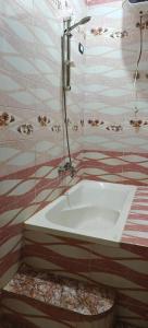 a bathroom with a bath tub with a shower at Family apartment LUXOR in Jazīrat al ‘Awwāmīyah +2 photos