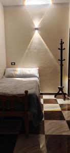 a bedroom with a bed with a light on the wall at Family apartment LUXOR in Jazīrat al ‘Awwāmīyah