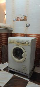 a washing machine sitting on the floor in a room at Family apartment LUXOR in Jazīrat al ‘Awwāmīyah
