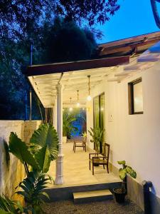 un portico di una casa con sedie e piante di TIKITIBE Villa & Restaurant a Hiriketiya