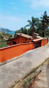 a brick road with a building and palm trees at Casa Ilhabela vista Mar Perequê in Santos