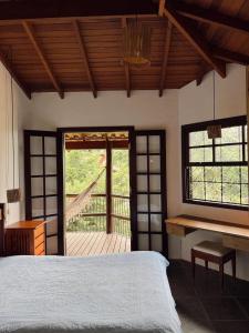 a bedroom with a bed and a desk in a room at Casa Ilhabela vista Mar Perequê in Santos