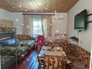 a room with a couch and a bed and a table at Akácvirág Vendégház in Ács