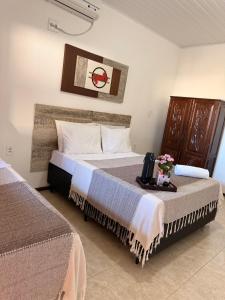 プラドにあるCasa de Majuのベッド2台、テーブルの上に花を飾った客室です。