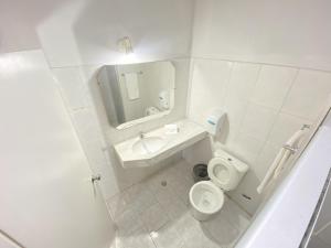 a white bathroom with a toilet and a sink at Nuevo Hotel in Rivera +72 photos