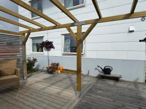 a wooden pergola on a deck next to a building at Sussi`s Guesthouse in Kungshamn