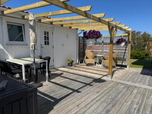 a wooden deck with a pergola and a table at Sussi`s Guesthouse in Kungshamn