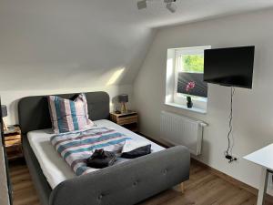 a bedroom with a bed with two cats sitting on it at Ferienhaus Salz & Seele in Husum +7 photos