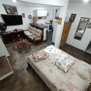 a living room with a bed and a kitchen at Casa em frente a praça principal in Rio das Flores