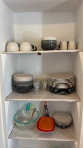 a refrigerator filled with plates and bowls and dishes at Au puits de Figa in Figanières