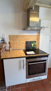 a kitchen with a counter with a stove top oven at Au puits de Figa in Figanières