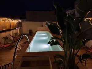 a swimming pool on a deck at night at BELLADORA Hotel Boutique in Lloret de Mar