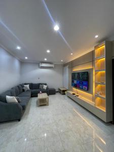 a living room with a couch and a tv at شقة ذات موقع رائع in An Nikāshah