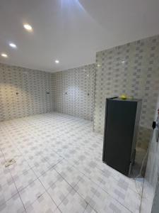 a large empty room with a white ceiling and tile floors at شقة ذات موقع رائع in An Nikāshah