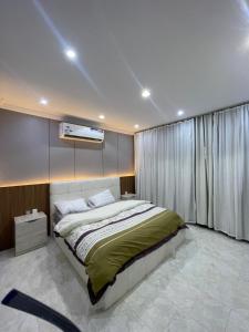 a bedroom with a bed and a tv on the wall at شقة ذات موقع رائع in An Nikāshah +2 photos