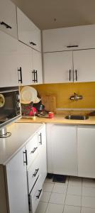 a kitchen with white cabinets and a microwave at Apartment Sama Beach in Hurghada