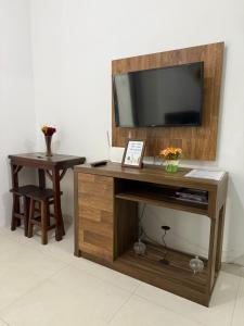 a wooden entertainment center with a tv and a table at Apartamento Aconchegante em Botafogo in Rio de Janeiro
