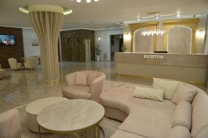 a hotel lobby with couches and a table and chairs at Ивелия Хотел и Спа - Ivelia Hotel & SPA in Dŭbnitsa