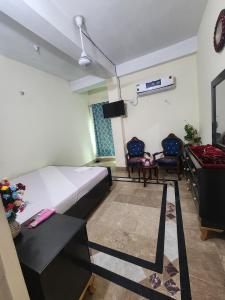 Un dormitorio con una cama y una mesa y sillas. en Royal Inn Guest House, en Harīpur