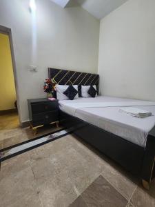 Un dormitorio con una cama grande y una mesita de noche. en Royal Inn Guest House, en Harīpur