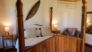una camera da letto con un letto a baldacchino e una sedia di Casa de Maria a Tiradentes Altre 106 foto
