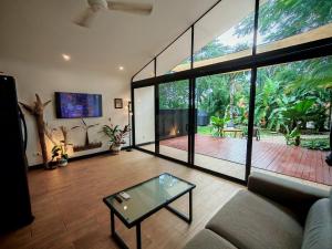 a living room with a couch and a glass table at Pyramid Tamarindo Luxury Hotel in Tamarindo