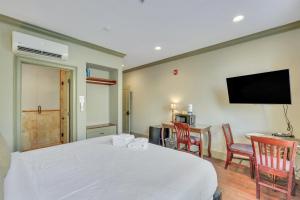 a bedroom with a white bed and a flat screen tv at McDonough's Inn Unit 1 by Lucky Savannah in Savannah +23 photos