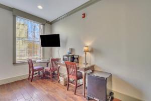 a room with a desk with chairs and a tv at McDonough's Inn Unit 1 by Lucky Savannah in Savannah