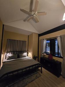 a bedroom with a bed and a ceiling fan at Carl and Ellie Home in Bangkok