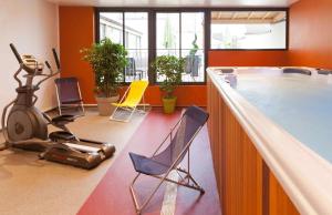 ein Zimmer mit einem Fitnessraum mit Stühlen und einem Laufband in der Unterkunft ibis Styles Beaune Centre in Beaune
