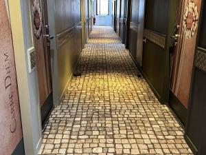 un couloir avec un sol carrelé dans un immeuble dans l'établissement ibis Styles Nimes Gare Centre, à Nîmes