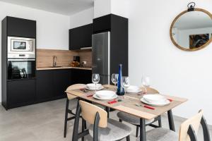 Un comedor con mesa y sillas y una cocina. en Los Ajaches - Caracolas, en Mácher 5 fotos más