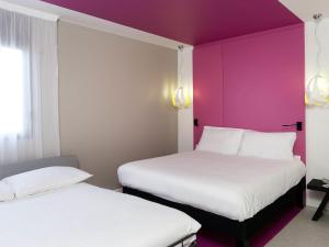 - 2 lits dans une chambre d'hôtel aux murs violets dans l'établissement ibis Styles Nimes Gare Centre, à Nîmes 48 autres photos