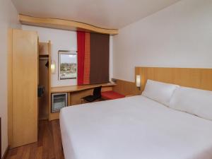 a hotel room with a white bed and a window at Ibis Lagos Ikeja in Ikeja +50 photos