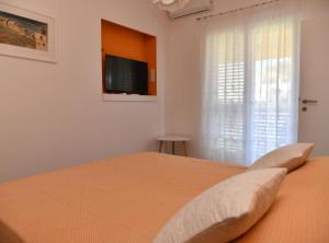 a bedroom with a bed with a flat screen tv at Apartments Near Sea Supetar in Supetar