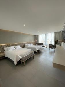 ein Schlafzimmer mit zwei Betten und ein Wohnzimmer in der Unterkunft Hotel Alcalà Centro in Guadalajara