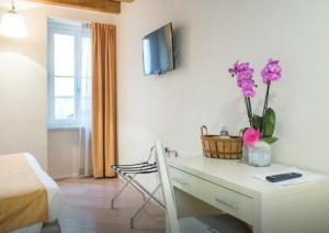 a room with a desk with purple flowers on it at La Corte Fiorita Como in Como