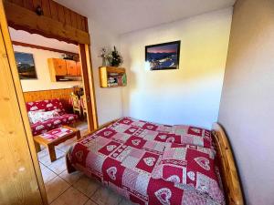 Un dormitorio con una cama y una sala de estar. en Résidence Villaret - Grand studio 4 personnes aux pieds des pistes, vue montagne. MAE-8891, en Les Menuires