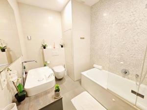 ルクセンブルクにあるElegant 3BR Retreat with terraces&parkingの浴槽、トイレ、洗面台を備えた白いバスルーム