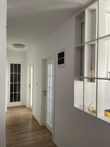 a living room with white walls and wooden floors at City View Prishtina in Pristina