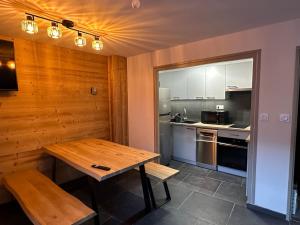 eine Küche mit einem Holztisch und einer Arbeitsplatte in der Unterkunft Appartement au pied des pistes Serre chevalier in La Salle Les Alpes