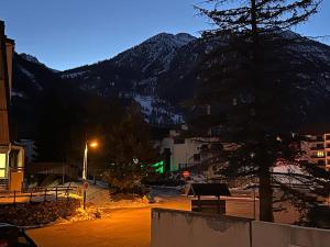 eine Straße in der Nacht mit einem Berg im Hintergrund in der Unterkunft Appartement au pied des pistes Serre chevalier in La Salle Les Alpes