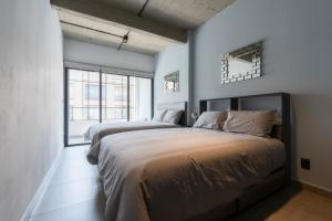 two beds in a bedroom with blue walls and windows at Zielo Rentals Palma ,Private balcony, Rooftop Walk to Zocalo in Mexico City