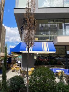 a building with blue umbrellas and tables and chairs at City View Prishtina in Pristina