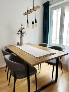 a dining room table with chairs and a vase on it at NEU! moderne Stadtwohnung in Ulm-Söflingen in Ulm